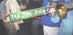 Photograph of a trombone that reads "Tax the Rich"